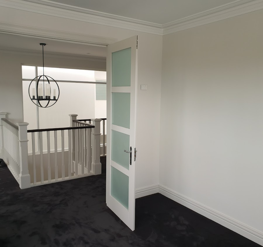 Upstairs hallway with painted walls, crown moulding, and door frames